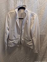 Full front view of white Adidas jacket on hanger