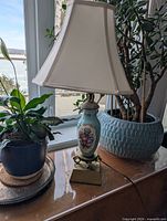 Full view of ceramic lamp with shade on table