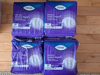 Four packs of Tena ProSkin Stretch Night adult diapers, three sealed and one opened