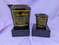 Front view of both Tia Maria ceramic jugs on plinth bases