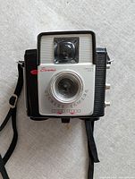 Front view showing lens, viewfinder, brand markings and controls