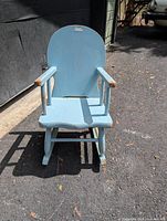 Front view of blue wooden child’s rocking chair showing seat, arms, backrest, rockers