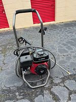 Front view of Blackmax pressure washer showing engine, hose, wand and frame