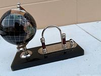 Overall view of globe and pen stand on black base