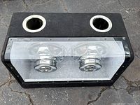 Front view showing enclosure, plexiglass window, two chrome subwoofers and dual ports