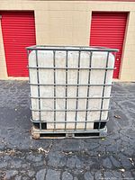 Front view of IBC tote showing steel cage and pallet base