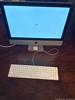 iMac front view on, Apple logo, keyboard shown