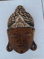 Front view of carved wooden Buddha mask