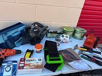 Overview of assorted power tools, hand tools, strap, tape measure, light bulbs, tool bag
