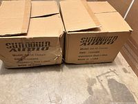 Two cardboard boxes showing exterior wear, labeled Sundown Audio, each containing a subwoofer