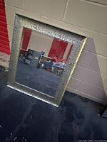 Full view of rectangular mirror leaning against wall