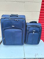 Front view of both navy Ricardo Elite suitcases showing overall design and relative sizes