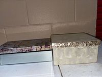 Two storage boxes side by side, showing exterior materials and sizes