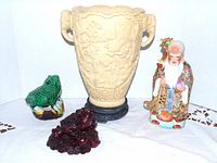 Group shot showing vase, porcelain immortal, green ceramic frog, red resin frog