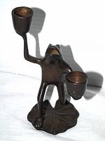front view of bronze frog candle holder showing both cups and lily pad base