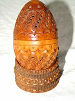 Egg-shaped carved coquilla nut container on ring base