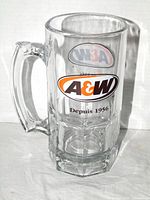 Front view of A&W glass mug showing bilingual logo, "Depuis 1956" text and handle