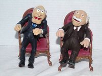 Front view of both figures seated in chairs displaying overall condition and appearance