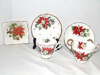 Group shot showing two holiday teacup and saucer sets and candy dish