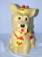 Front view of plastic Scottie dog bank showing hat, scarf and pouch details