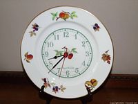 Front view of Royal Worcester Evesham plate clock showing fruit motif and dial
