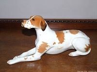 Side view of porcelain pointer dog figurine on wood surface