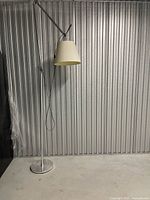 Full view of adjustable metal floor lamp with beige shade