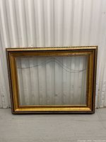 Front view of empty gold-tone frame with translucent front panel
