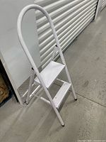 Front view of unfolded white two-step ladder