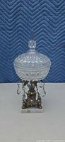 Front view of covered crystal compote showing lid, bowl, prisms, and base
