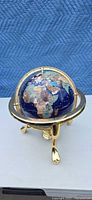 Front view of globe on brass tripod stand