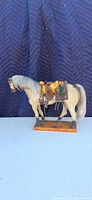 Left side profile of horse figurine on base
