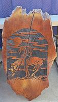 Front view of carved live-edge wood slab depicting rider on horse