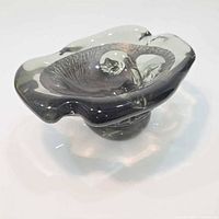 Angled view showing freeform rim and smoky gray translucent glass