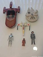 All six items laid out: Landspeeder, Millennium Falcon, X-Wing, C-3PO, Jawa, Death Star Commander