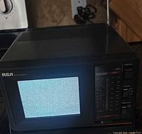 Front view powered on showing static image on CRT screen, antenna extended