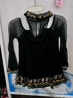 Full view of black embroidered mesh top on hanger