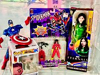 Group shot of all four Marvel items including Captain America, Funko Pop box, Spider-Woman carded figure, Sersi boxed figure