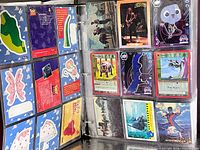 Binder open showing puzzle-style Toy Story cards and assorted MetaZoo and rock music cards