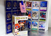 Binder opened showing card backs and fronts with Funko Pop figure in front