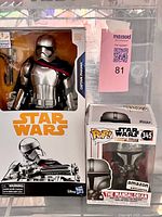 Front view of sealed Captain Phasma figure box next to sealed Mandalorian POP! #345 box