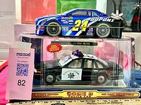 DuPont #24 stock car displayed atop packaged Code 3 CHP police car