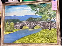 Full view of framed painting showing bridge, river and signature tag
