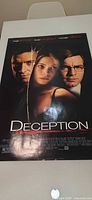 Full view of Deception movie poster on table