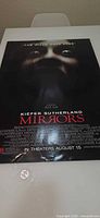 Full view of Mirrors poster on table