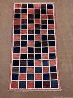 Full view of rug showing entire checkerboard design and fringe