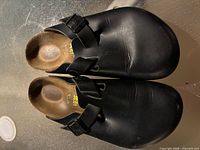 Top view of both clogs showing leather uppers, buckle straps, and overall condition