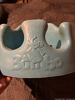 Front view of blue Bumbo seat showing embossed logo