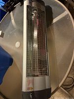 Front view of silver UFO infrared heater with grille and element