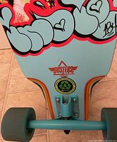 Underside tail showing Dusters logo, teal truck, teal wheel, eco resin emblem